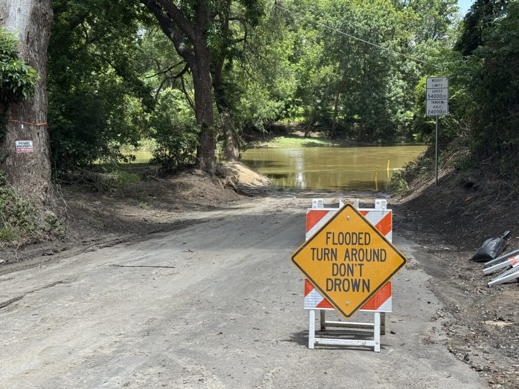 Turn Around Don't Drown sign in front of flooded roadway.